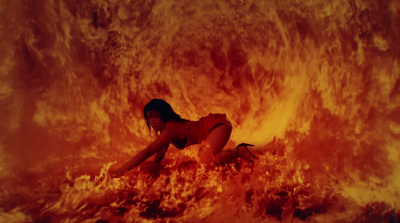 a woman laying on the ground in front of a fire