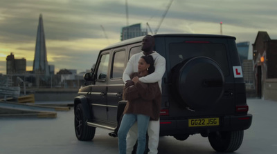 a man and a woman standing next to a car