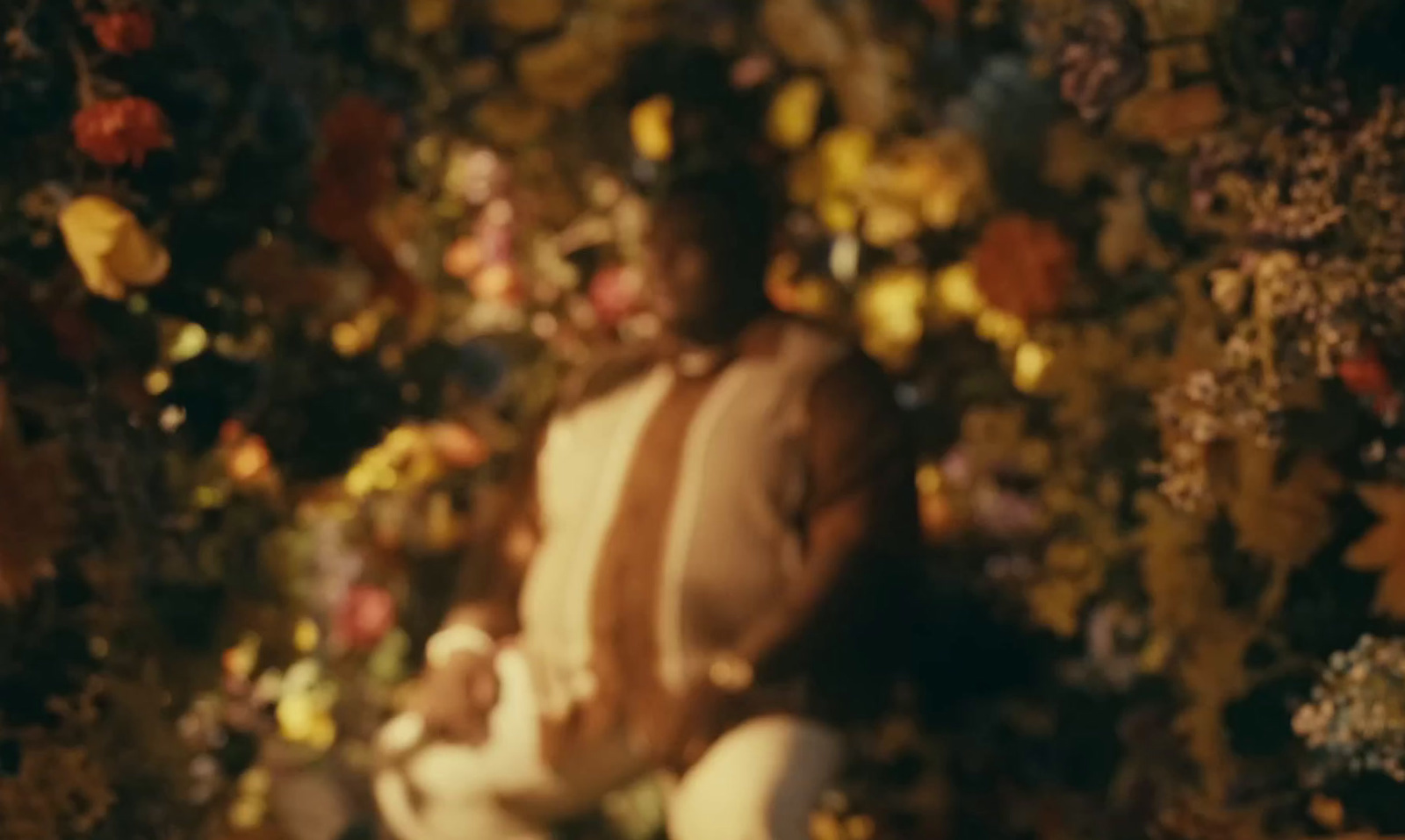 a man standing in front of a wall of flowers