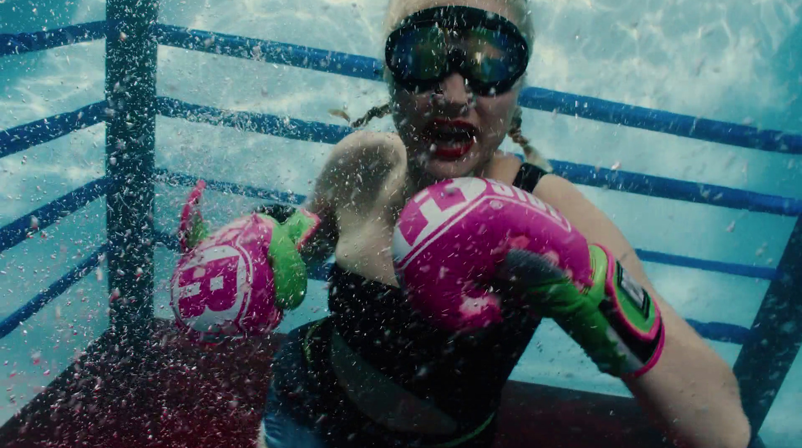 a woman wearing goggles and boxing gloves in the water