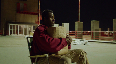 a man sitting in a chair holding a paper bag