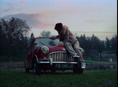 a man sitting on the hood of a red car