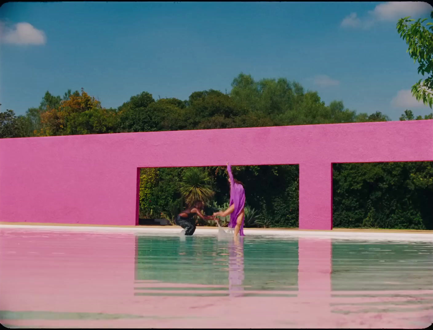 a woman in a purple dress standing in a pool