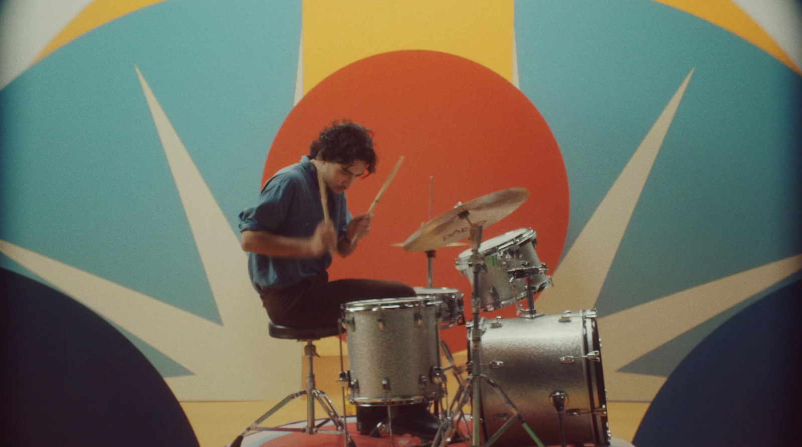 a man sitting on top of a drum set