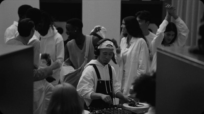 a group of people standing around a dj booth