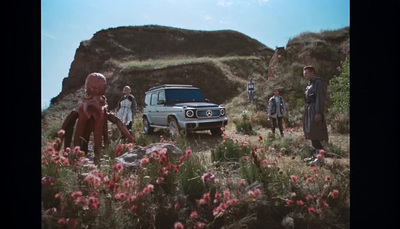 a group of people standing in a field next to a truck