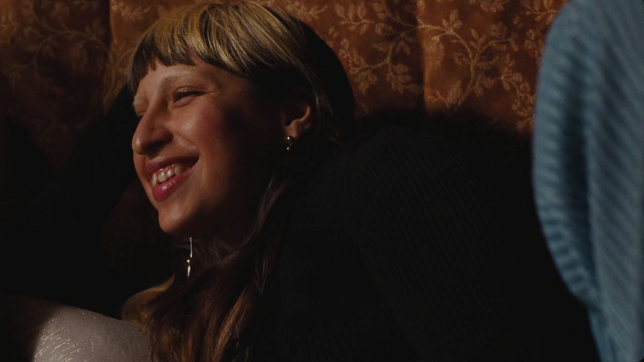 a woman smiling while sitting in a chair