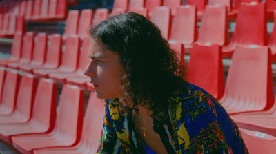 a woman sitting in front of a row of red chairs