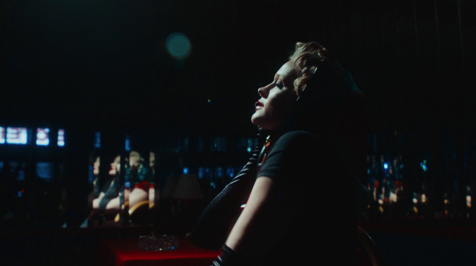 a woman sitting on a red chair in a dark room