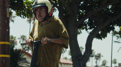 a man wearing a helmet and holding a scooter