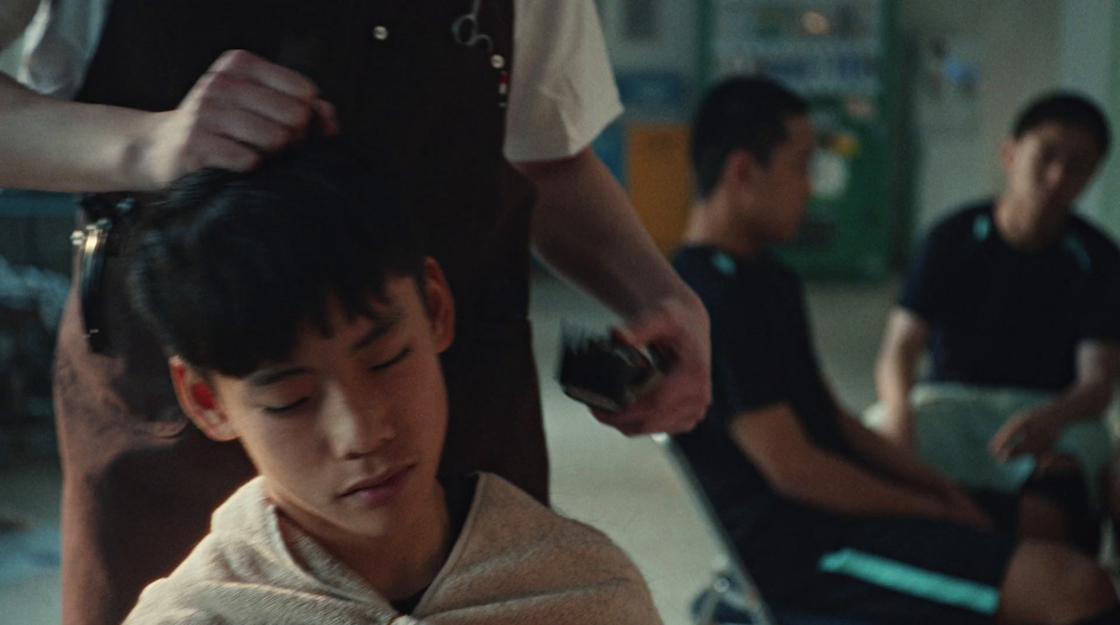 a young boy getting his hair cut by a barber