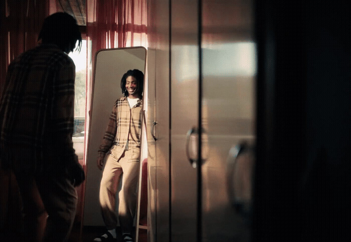 a man standing in front of a mirror in a room