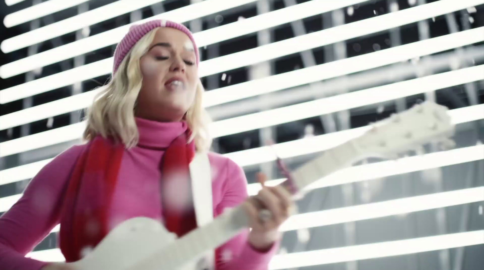 a woman playing a guitar in front of a window