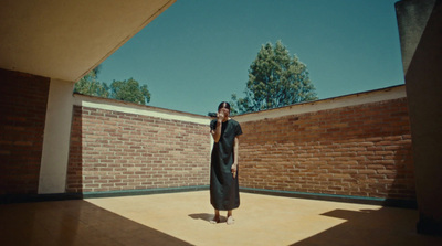 a woman in a black dress standing in a courtyard