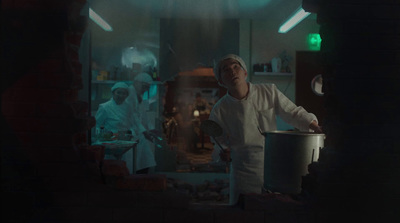 a man standing in a kitchen holding a pot