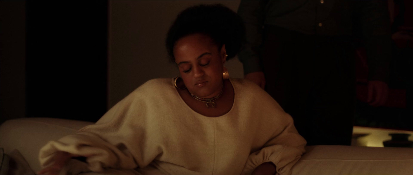 a woman sitting on a couch looking at a book