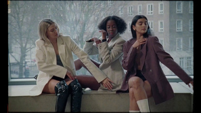 three women sitting on a ledge in front of a window