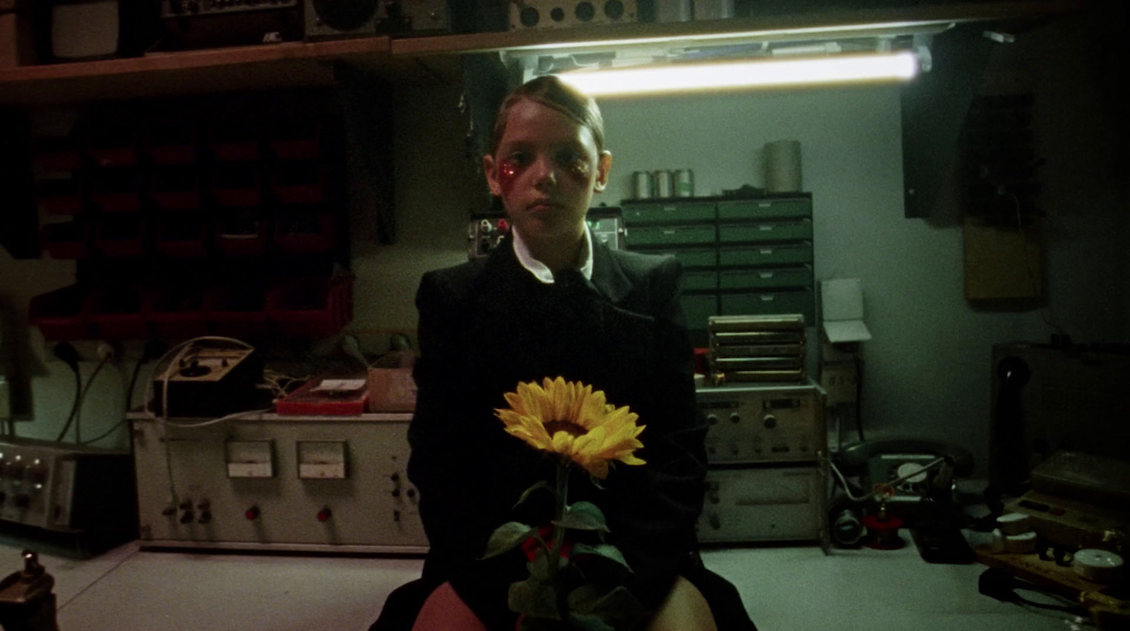 a woman holding a yellow flower in a room