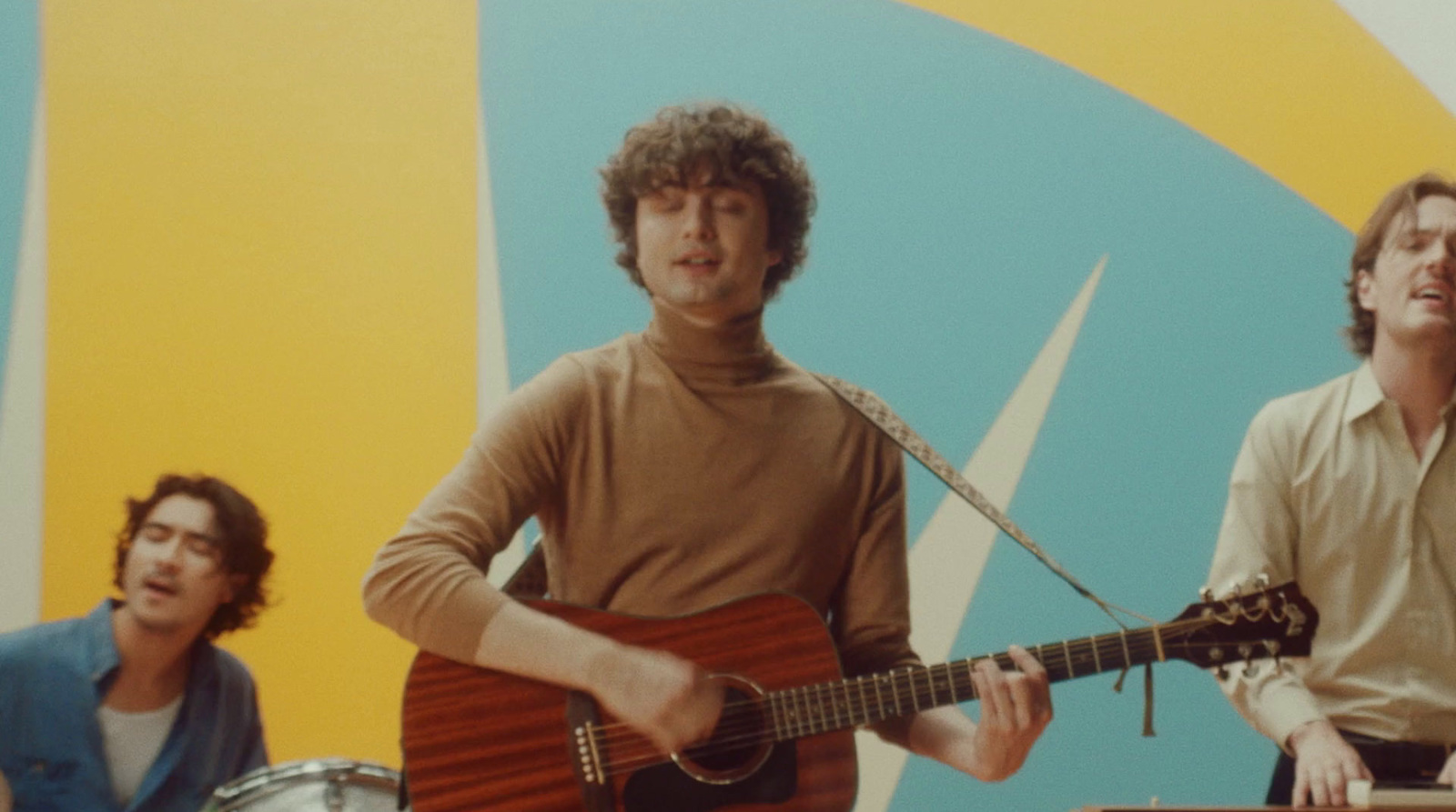 a group of men standing next to each other holding guitars