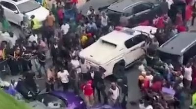 a group of people standing around a white car