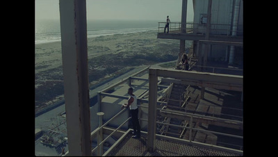 a man standing on top of a building next to the ocean