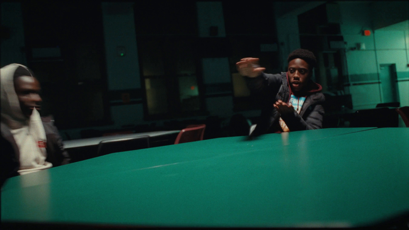 two people sitting at a table in a dark room