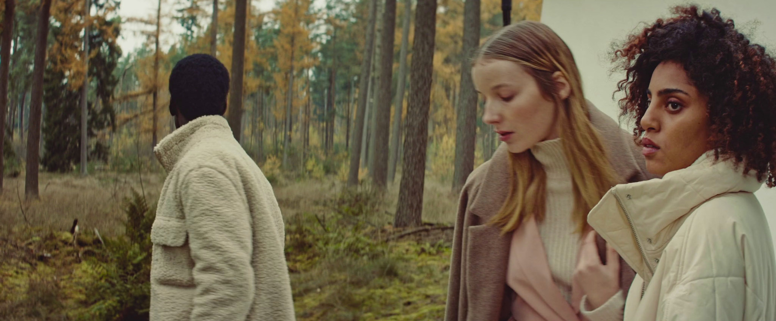 a couple of women standing next to each other in a forest