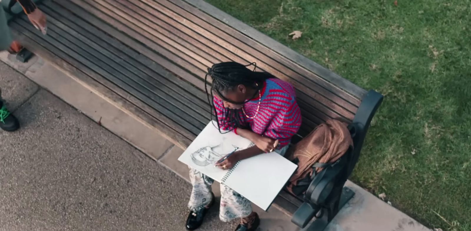 a woman sitting on a bench writing on a piece of paper