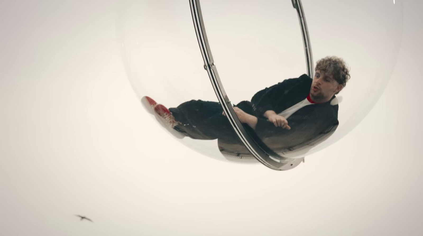 a man is sitting in a glass ball