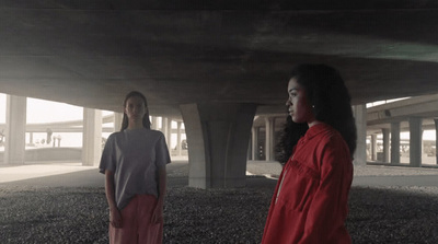 a couple of women standing under a bridge