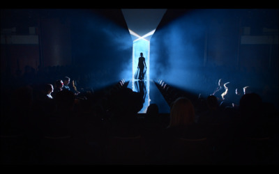 a person standing on a stage in front of a crowd