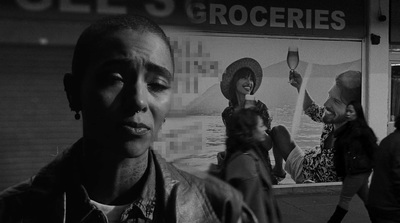 a black and white photo of a man standing in front of a store