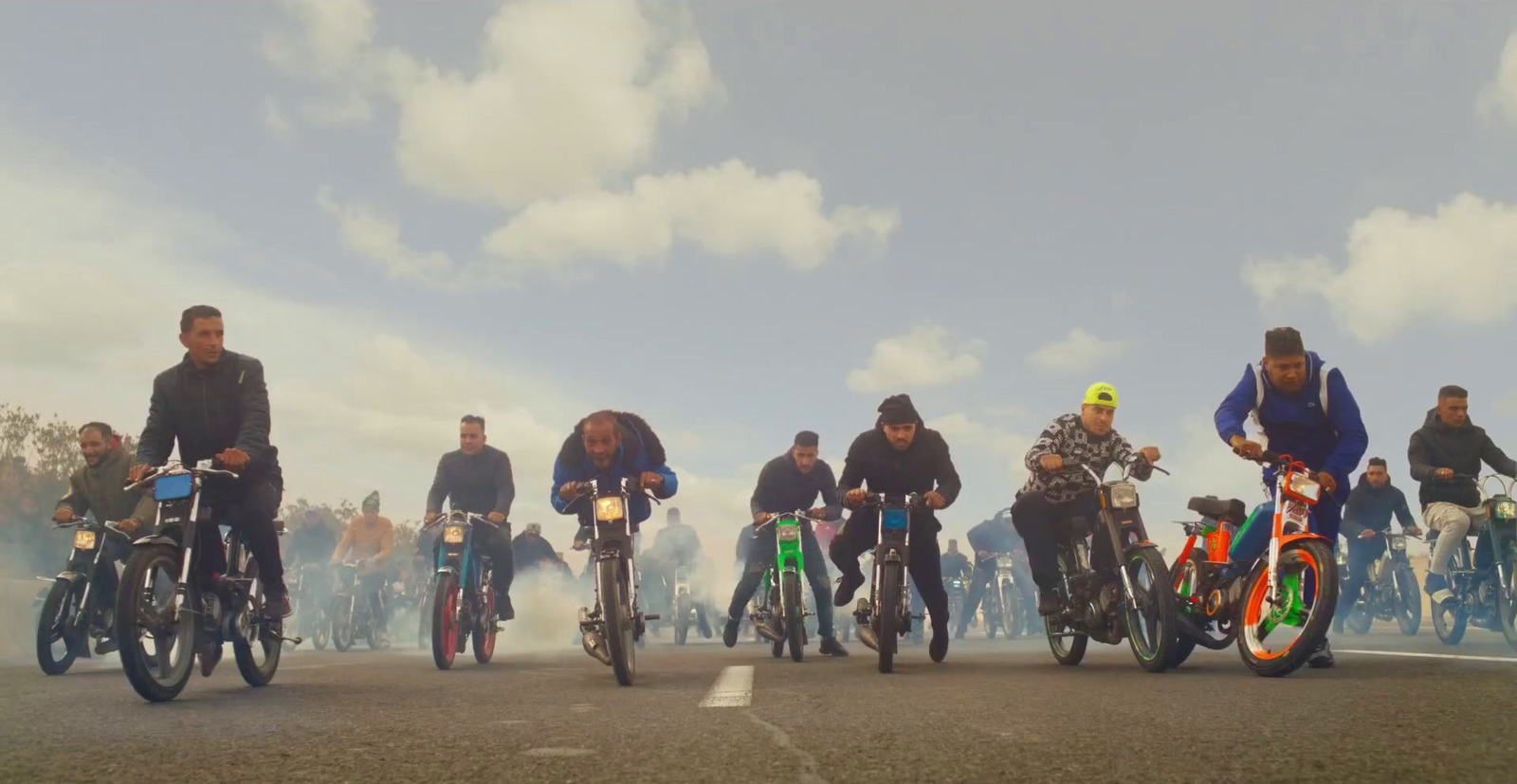 a group of people riding motorcycles down a street