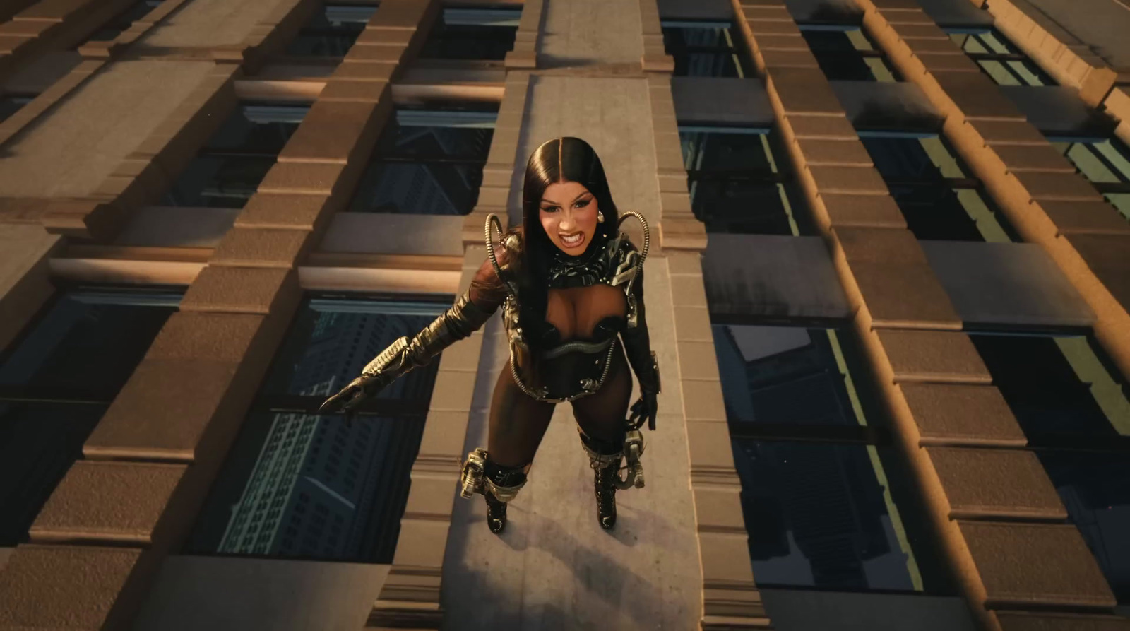 a woman in a futuristic suit is standing on a ledge in front of a building