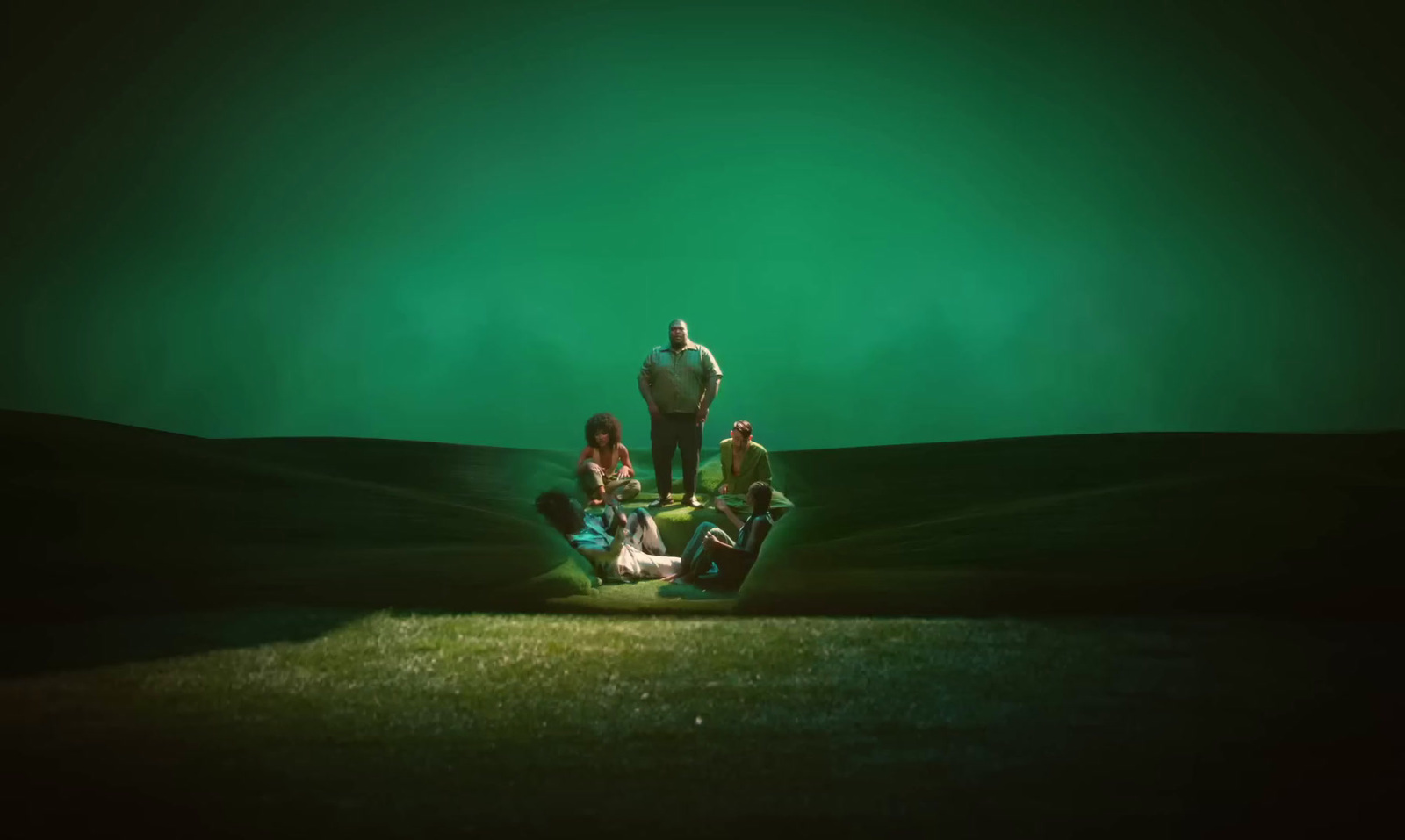 a group of people standing on top of a green field