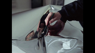 a person cutting a piece of glass with a knife