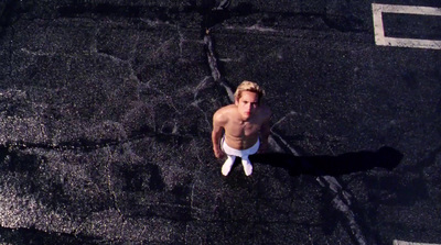 a shirtless man standing on a street corner