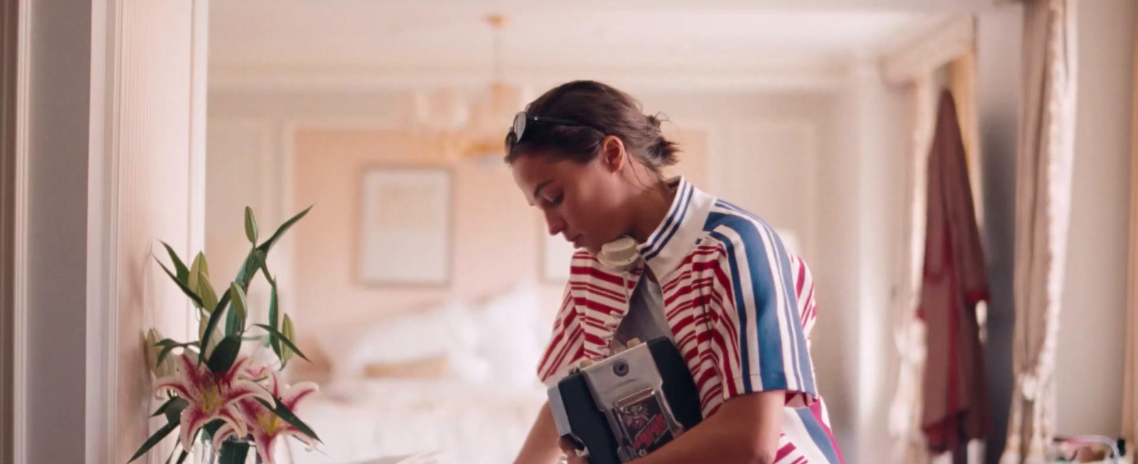 a woman in a red, white, and blue striped shirt cutting a cake