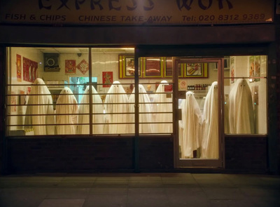 a store front at night with clothes in the window