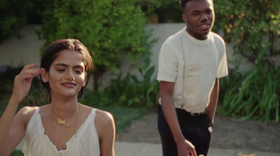 a man standing next to a woman in a white top