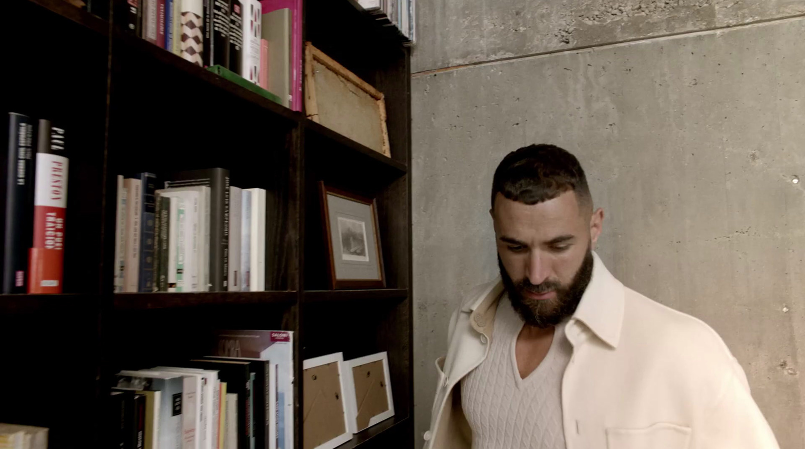 a man standing in front of a book shelf