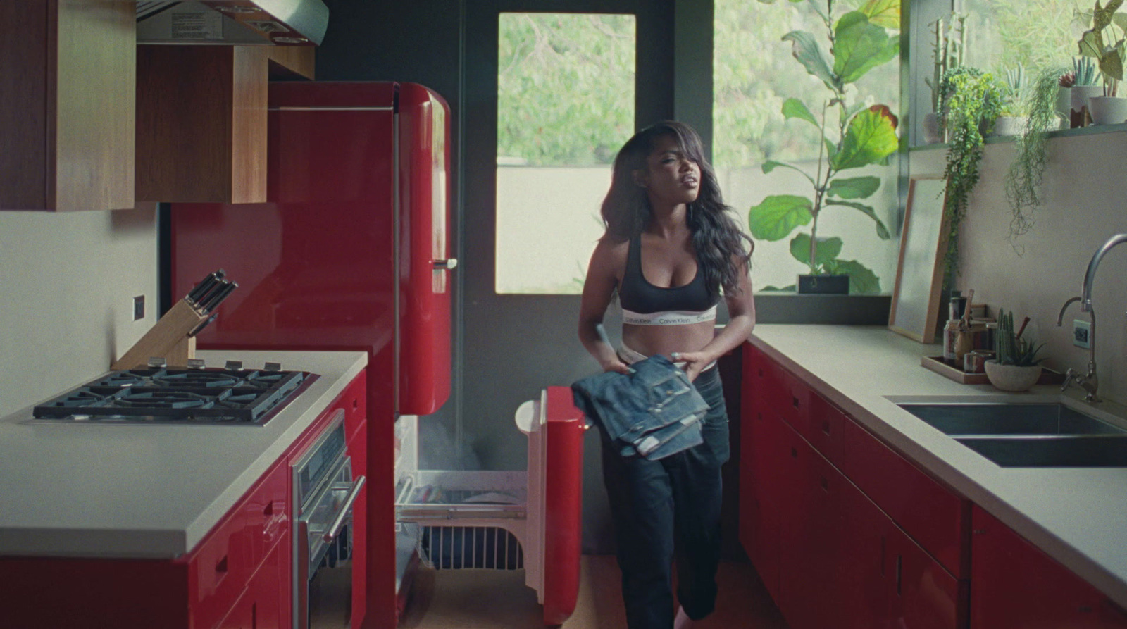 a woman standing in a kitchen next to a stove top oven