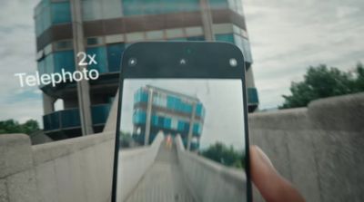 a hand holding a cell phone taking a picture of a building