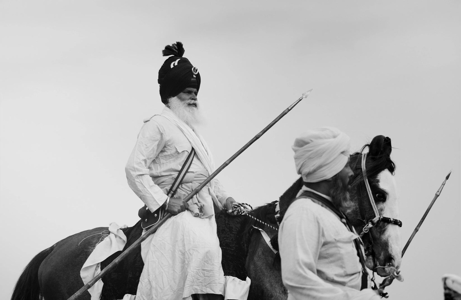 a man riding on the back of a horse next to another man