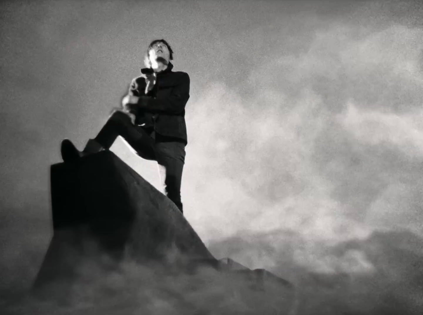 a man standing on top of a large rock