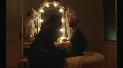 a woman sitting on a bed in front of a mirror