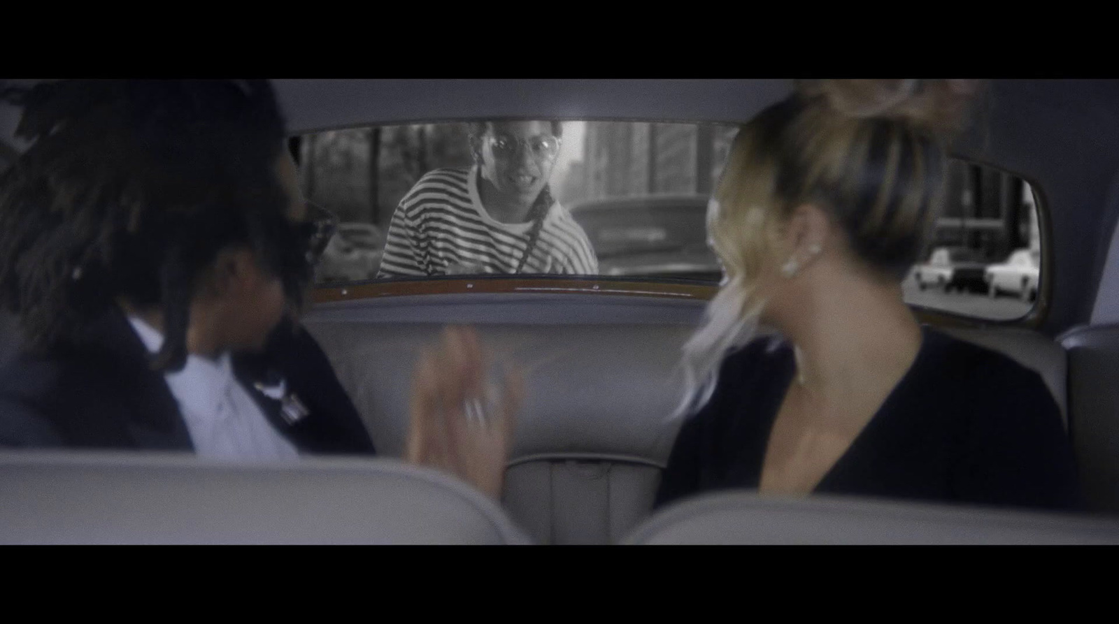 a man and woman sitting in the back of a car