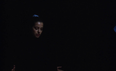 a woman in a dark room with a laptop