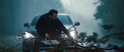 a man standing next to a car in the rain