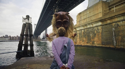 a little girl standing next to a big bridge